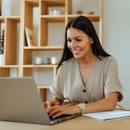 a woman sitting at a table using a laptop